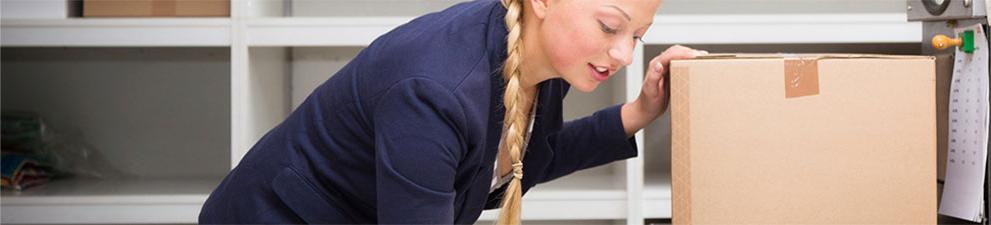 Woman checking shipping box weight and postage.